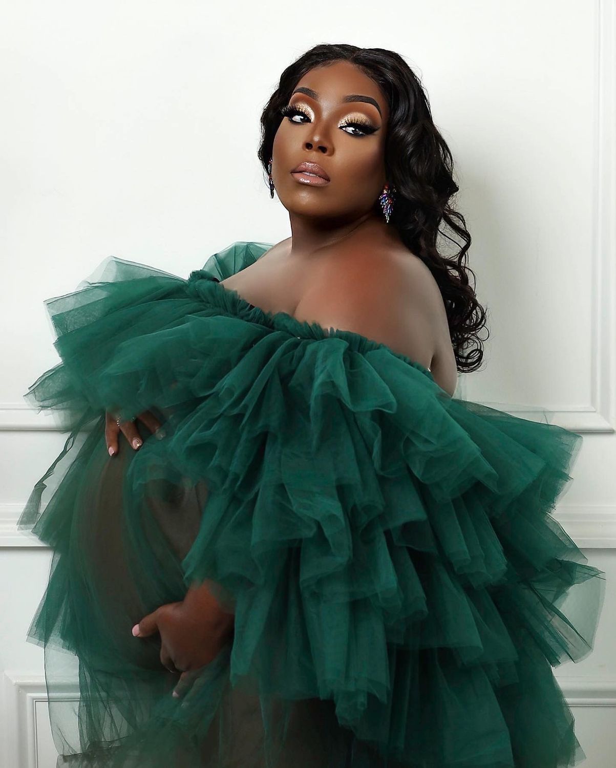 Maternity portrait in an emerald tulle gown with tropical greenery