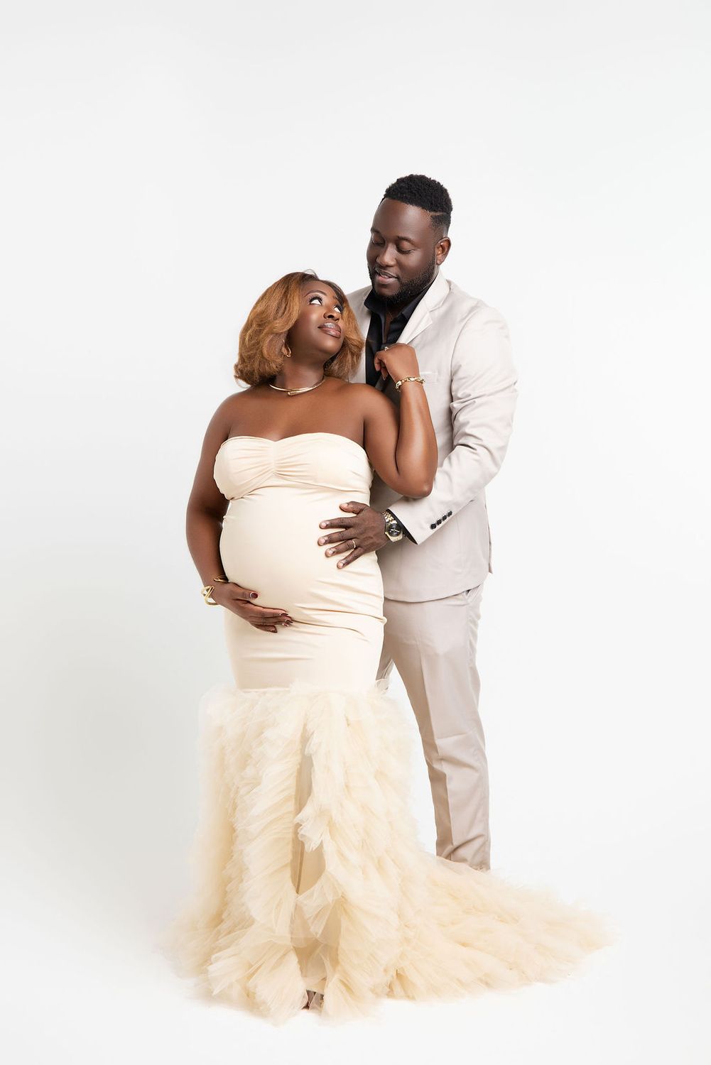 Full length studio maternity portrait in a peach mermaid gown with pampas grass