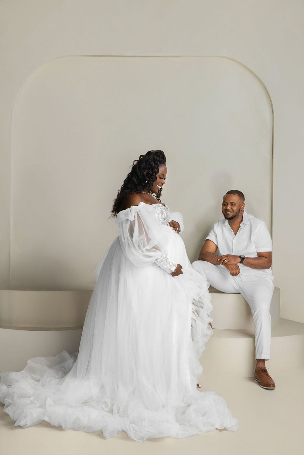 Profile of an expectant mother in a trailing white tulle gown