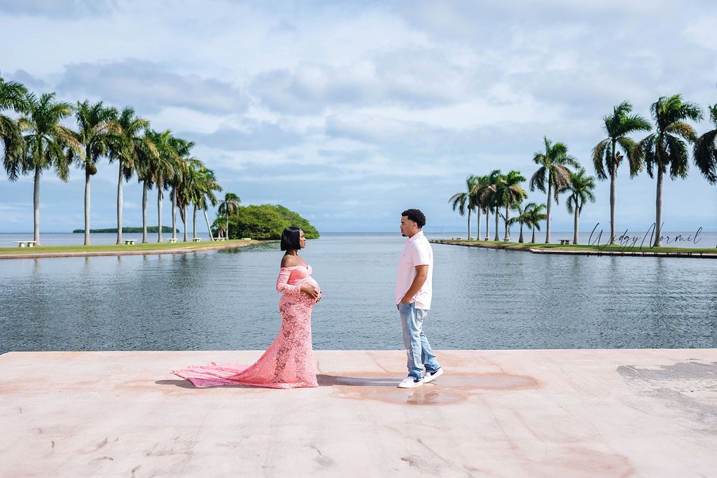 Maternity portrait in a pink lace gown on the terrace at Deering Estate