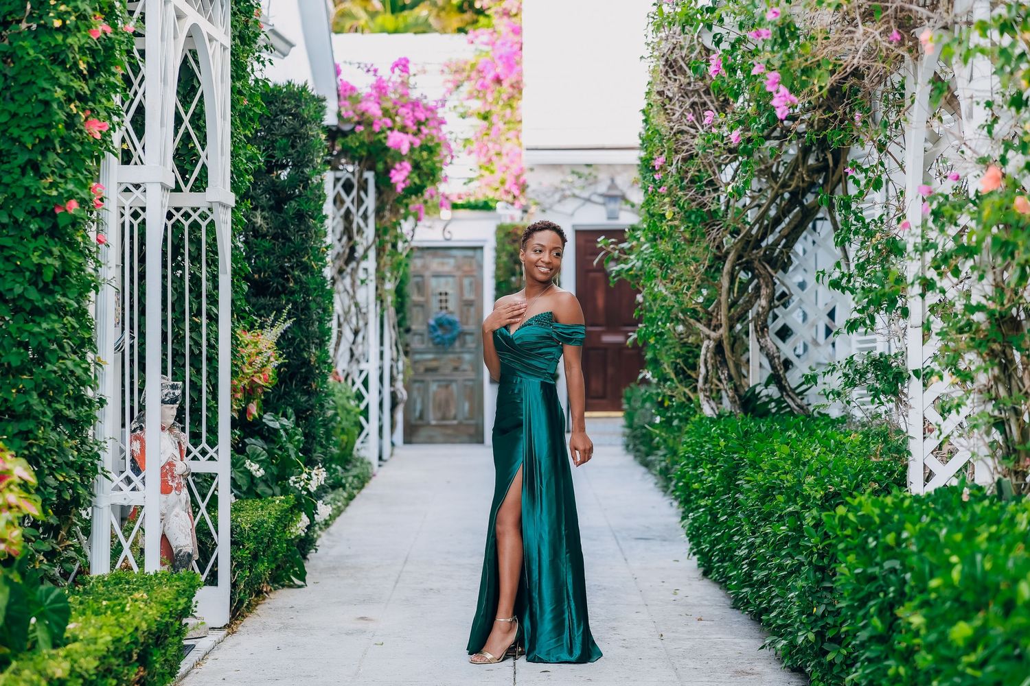 Expecting mother in a teal gown in a bougainvillea lined alley