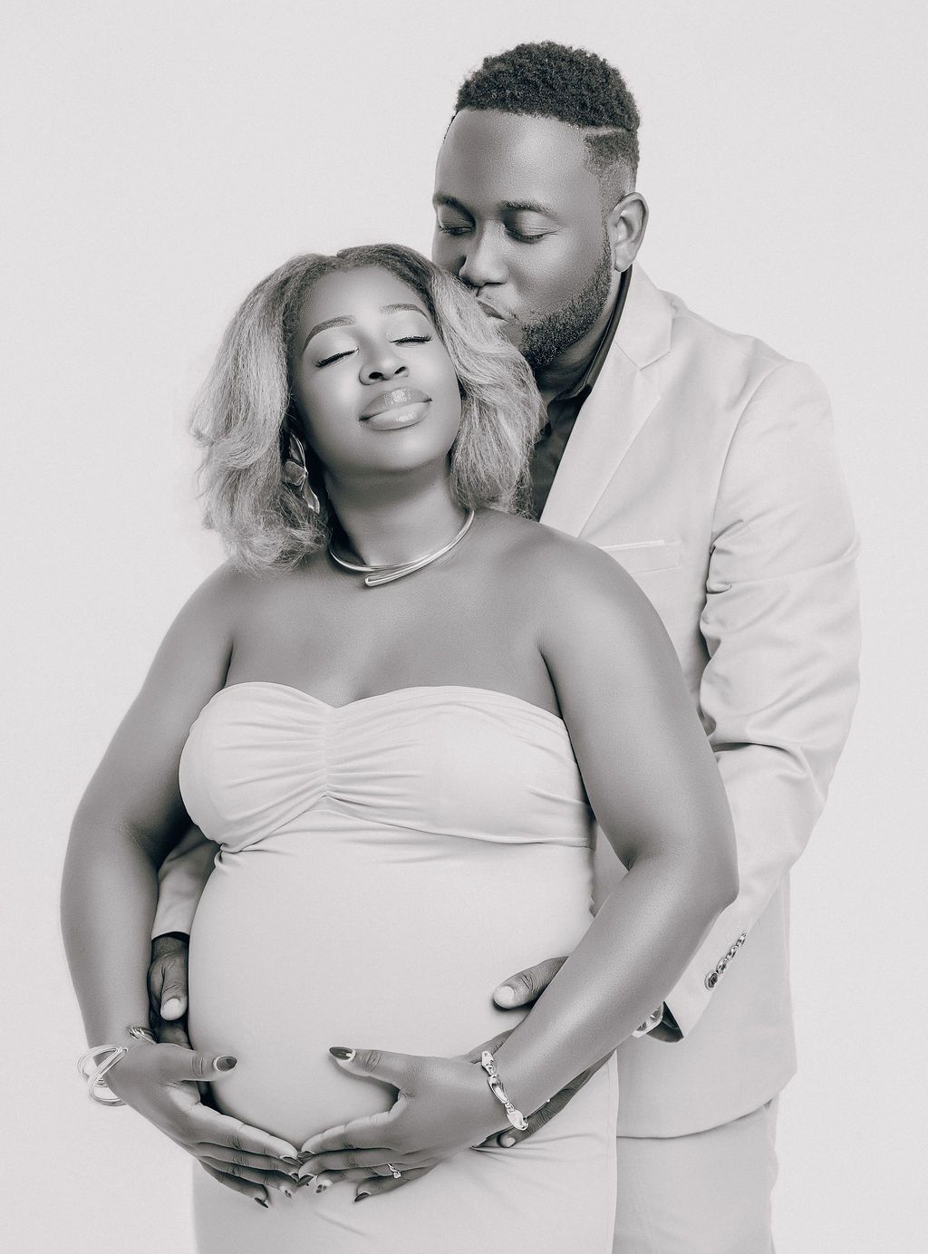 Black and white maternity portrait, expectant mother in a fitted gown