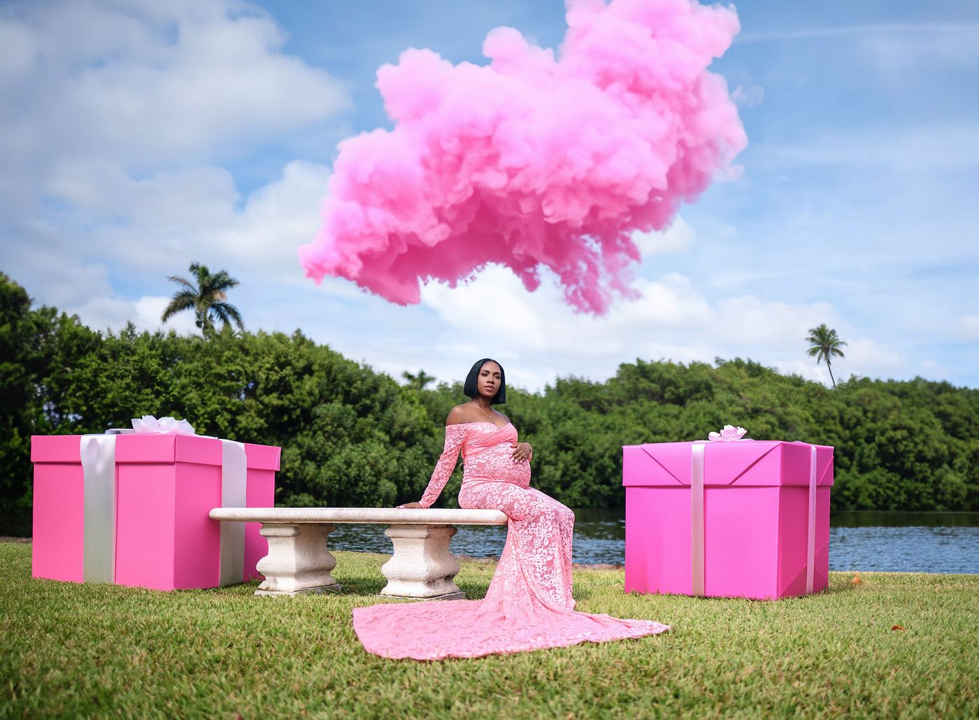 Pink smoke rising behind an expectant mother at a gender reveal session