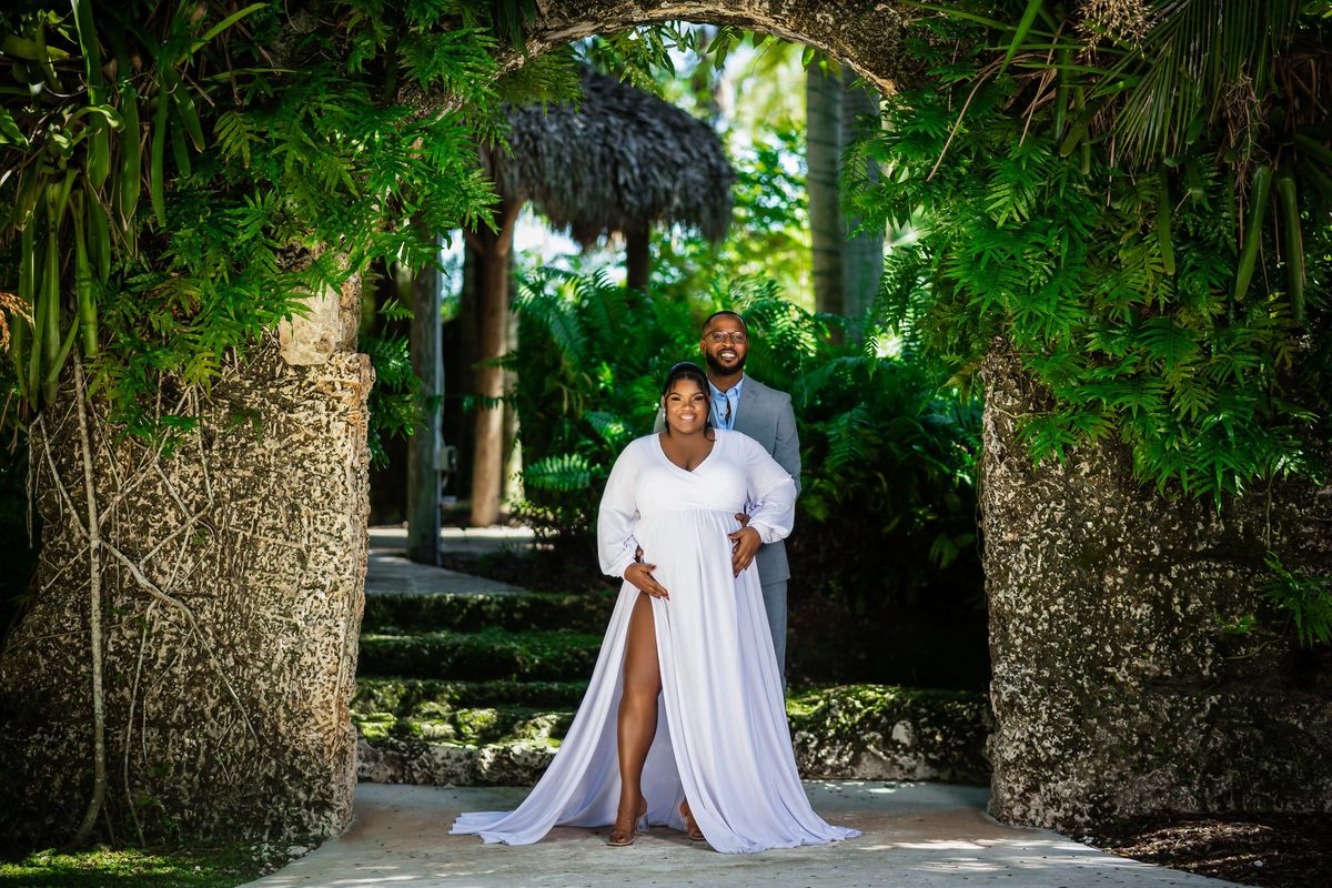 Maternity portrait in a white gown in a tropical Miami garden
