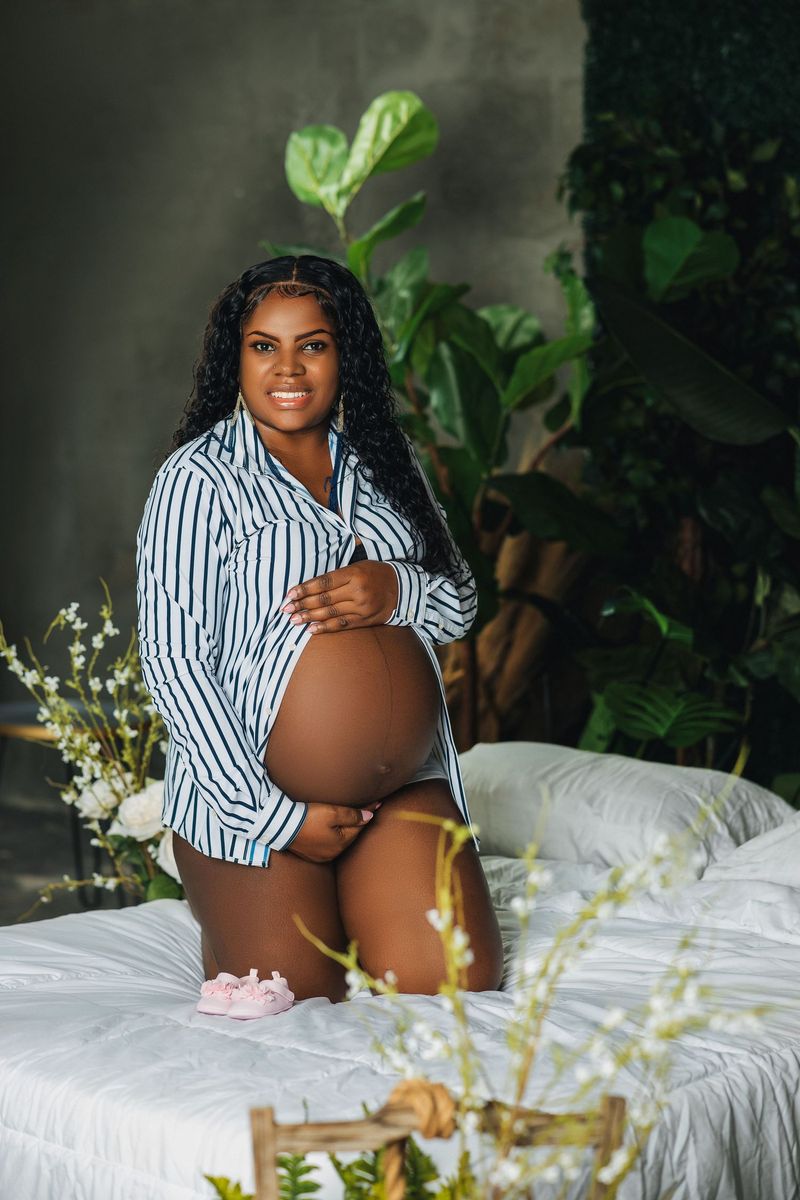 Expectant mother in a striped shirt in a soft, light filled studio setting