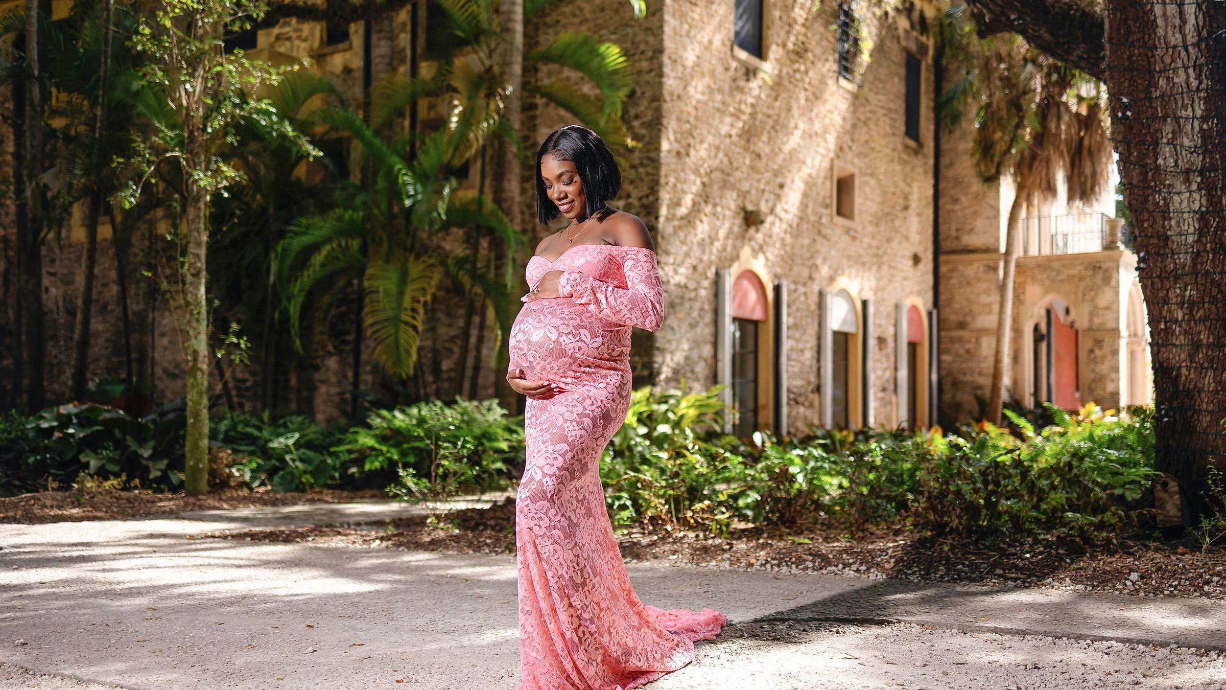 Expectant mother in a pink lace gown on the drive at Vizcaya in Miami
